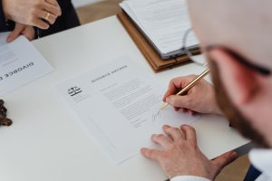 Advokat i klijent za stolom potpisuju pravni dokument – priprema dokumentacije u radnom sporu